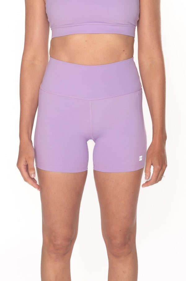 Woman wearing a purple athletic outfit on a white background