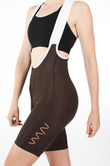 Women's Velocity 2.0 Cycling Bib Shorts. Brown bib shorts with tan WYN republic logo on thigh.