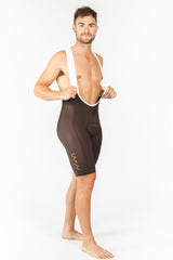 Model wearing men's mocha Velocity 2.0 Cycling Bib Shorts. Cycling shorts with upgraded stretch straps for flexibility.