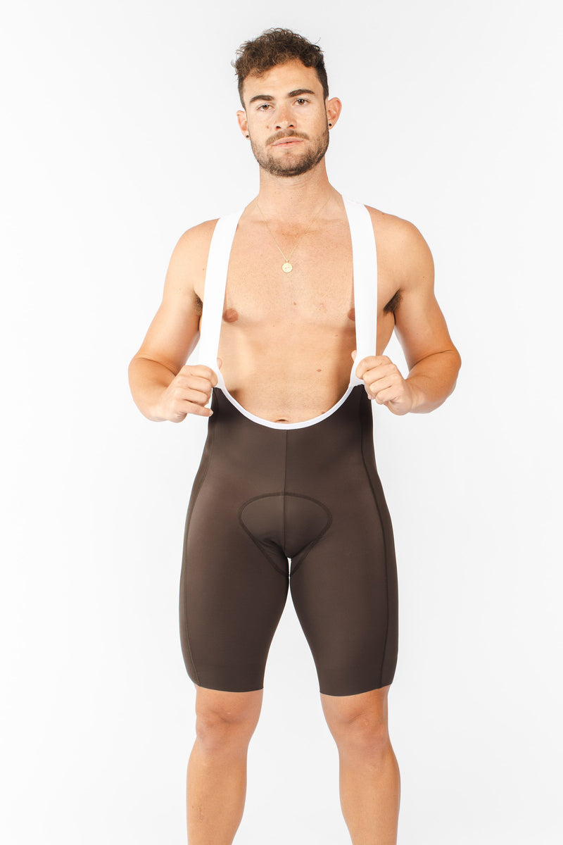 Model wearing men's mocha Velocity 2.0 Cycling Bib Shorts. Cycling shorts with stretch straps for comfort.